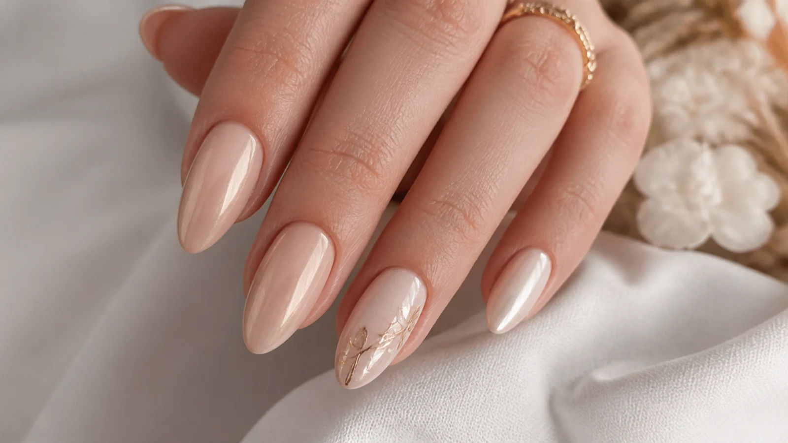 Bridal almond nails in sheer nude with a soft gold chrome glaze and a single accent nail