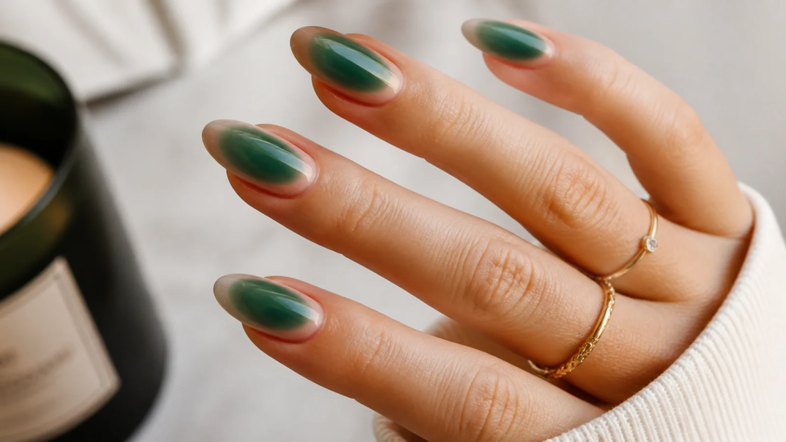Long almond emerald green aura nails with a jewel-toned glow over a sheer nude base