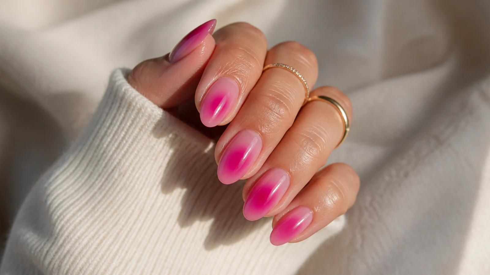 Hot magenta aura nails with a vivid pink center glowing out of a sheer pink base