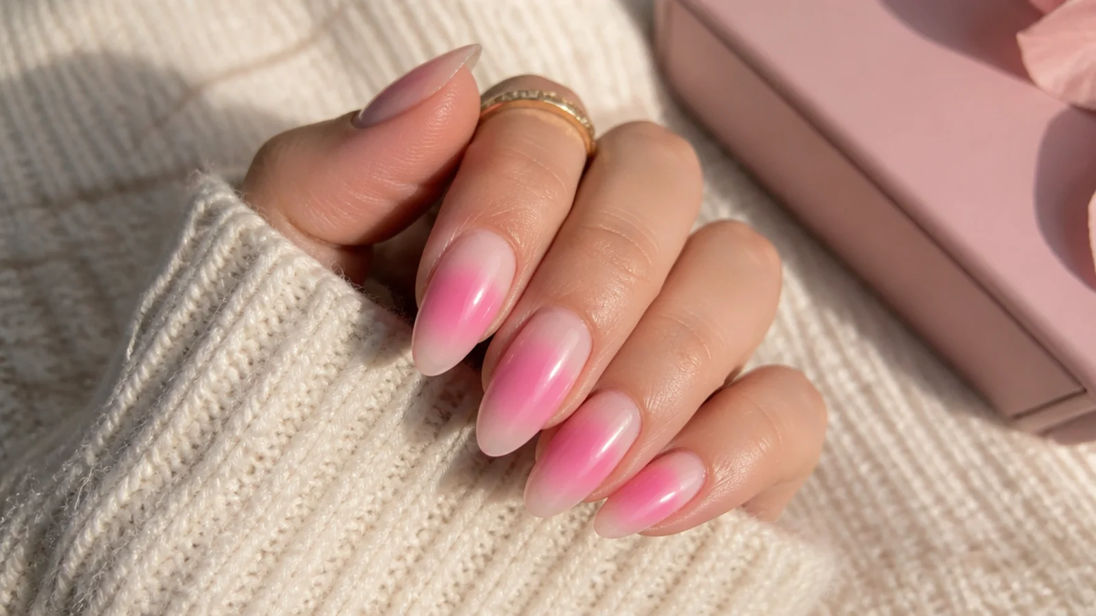 Almond pink aura nails with a bubblegum pink halo glowing from the center of a sheer nude base