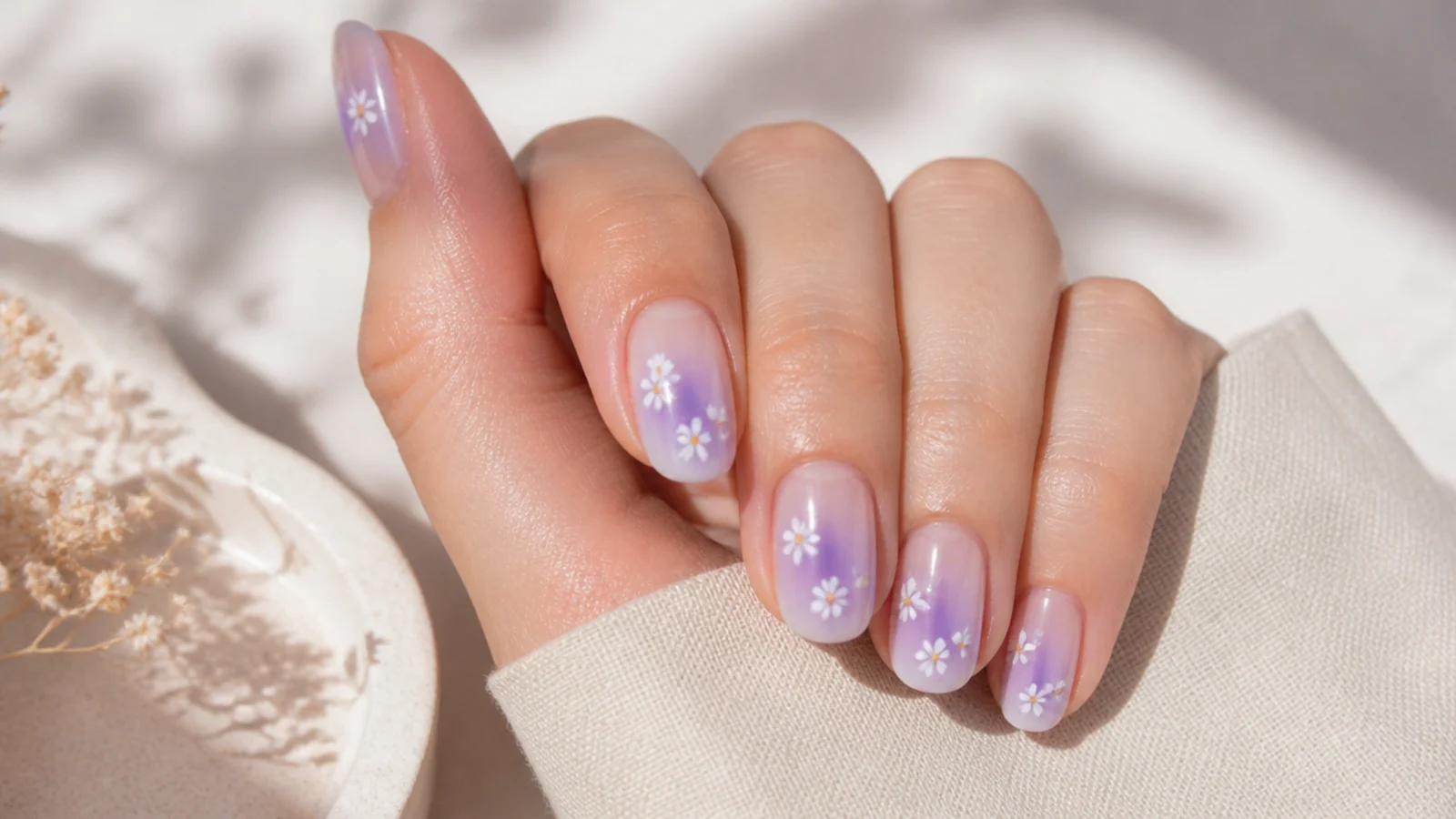 Lilac aura nails with small white hand-painted daisies over the purple halo
