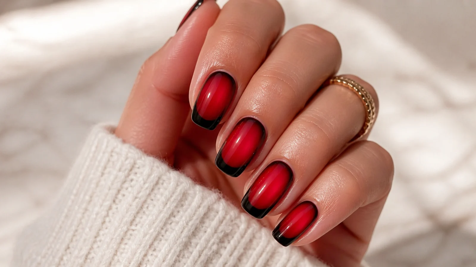 Red aura nails with a crisp black French tip band over the blurred red center