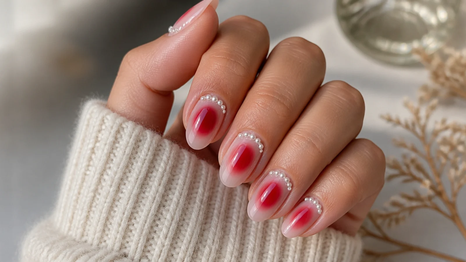 Red aura nails with tiny white pearl beads glued along the cuticle line