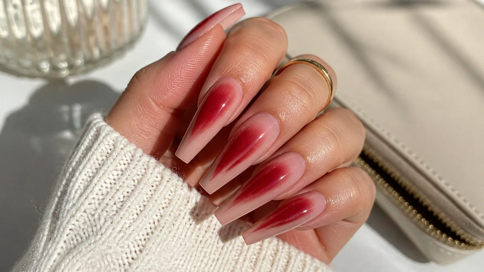 Long coffin red aura nails with a stretched red glow running down the tapered nail