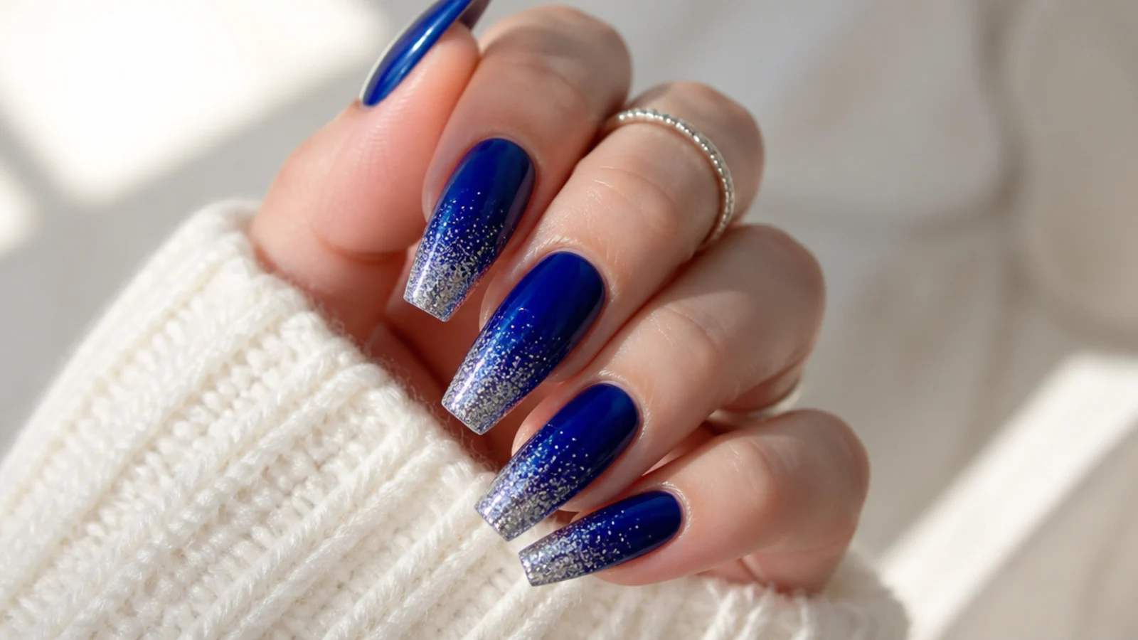 Royal blue coffin nails with silver glitter fading from the tip