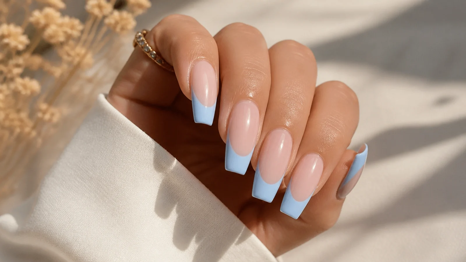 Sky blue French tip coffin nails with a sharp smile line on a nude base