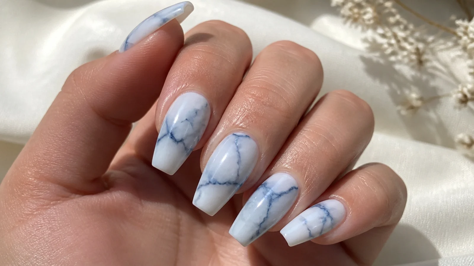 Blue and white marble coffin nails with fine veining on a milky base