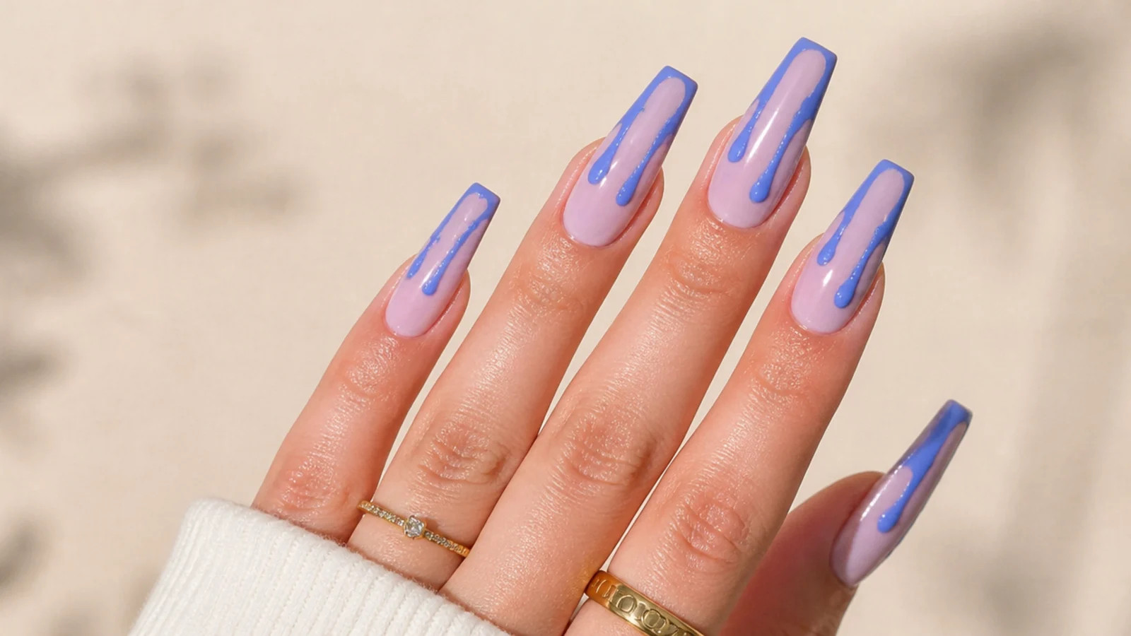 Blue drip coffin nails with paint drips running from the cuticle downward