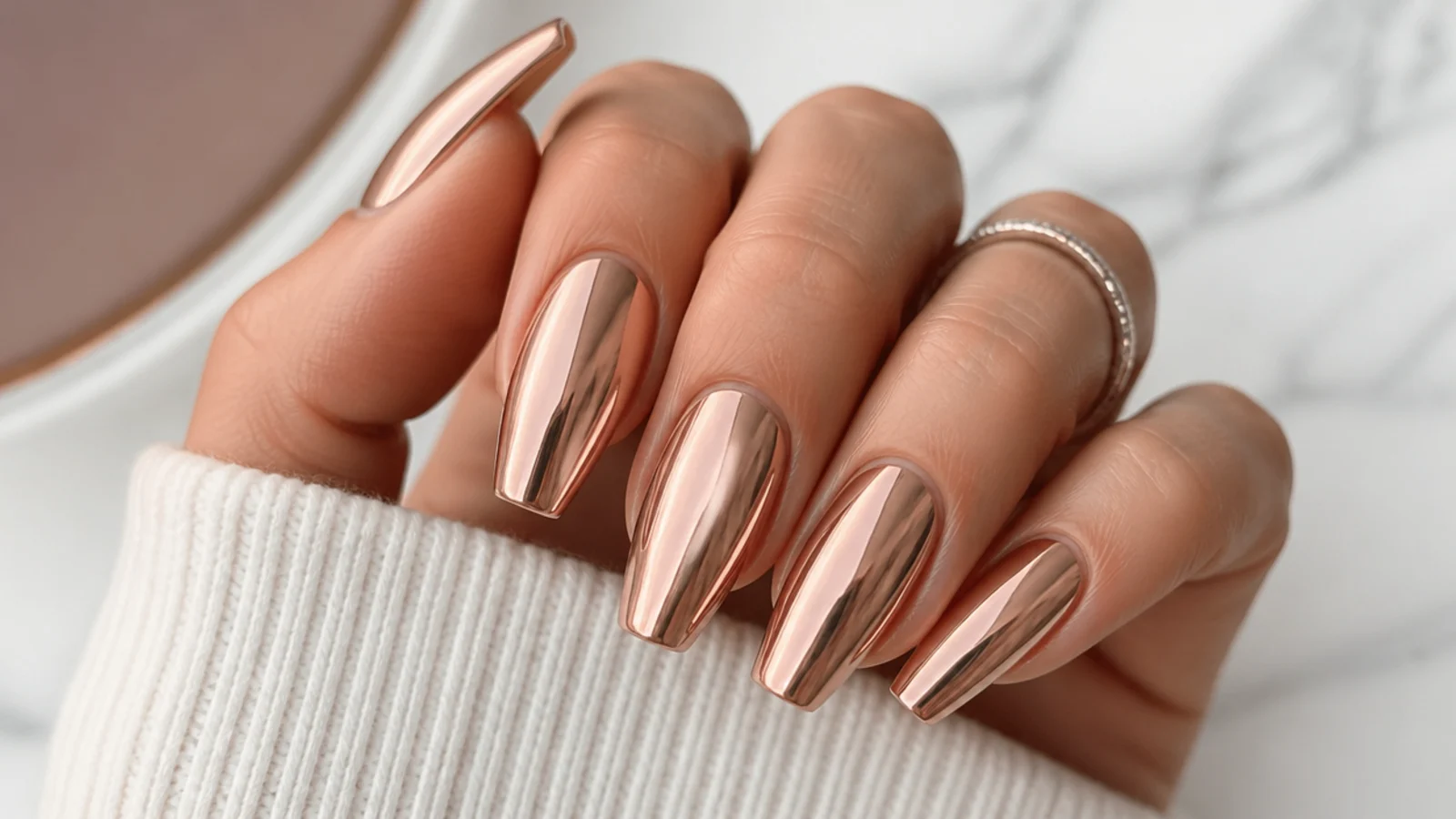 Long rose gold chrome coffin nails with a warm metallic mirror sheen