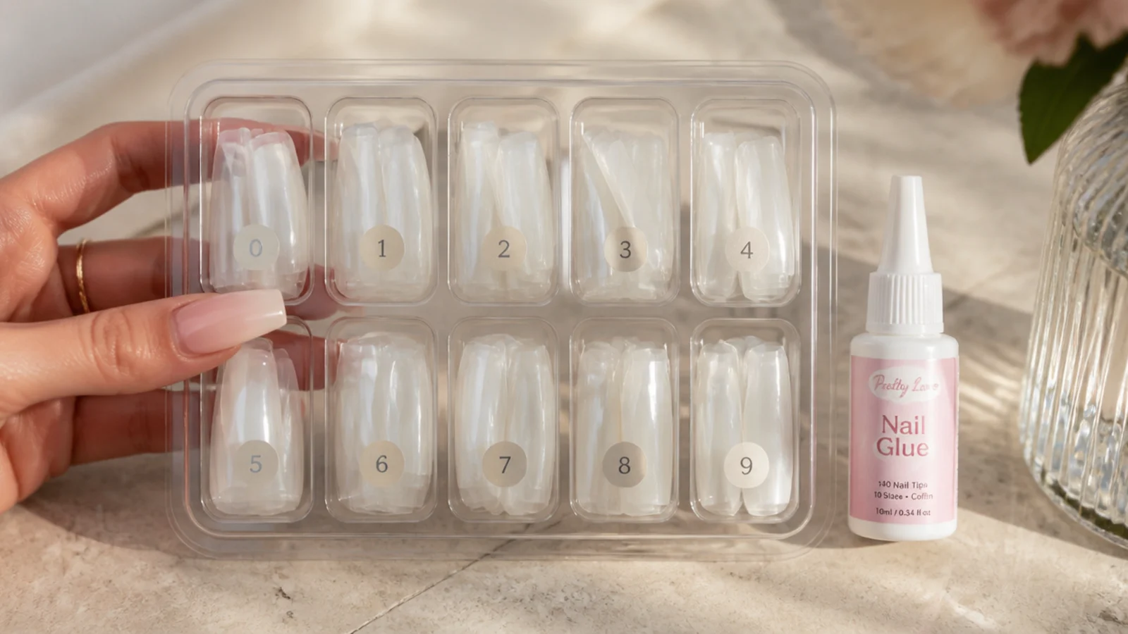 A tray of 140 bare full cover coffin nail tips in ten sizes with a bottle of nail glue