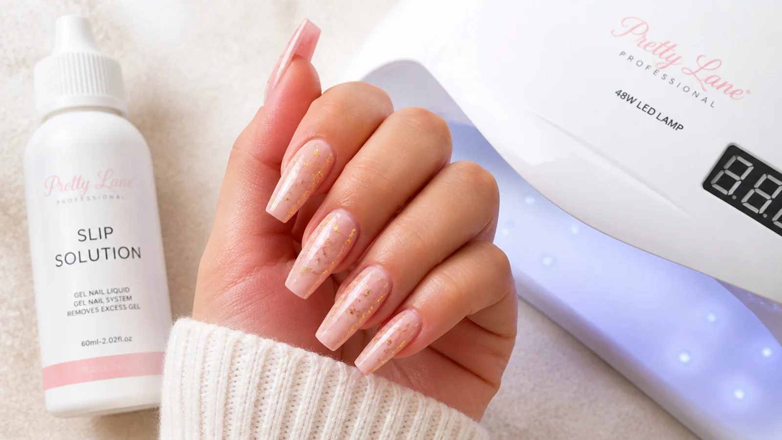 Medium coffin soft gel extension tips beside a slip solution bottle and a 48 watt LED lamp