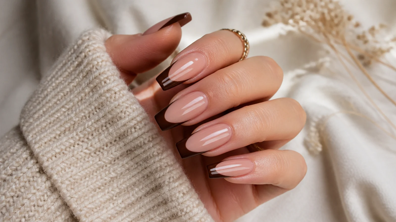 Coffin nails with a chocolate brown French tip on a sheer nude base