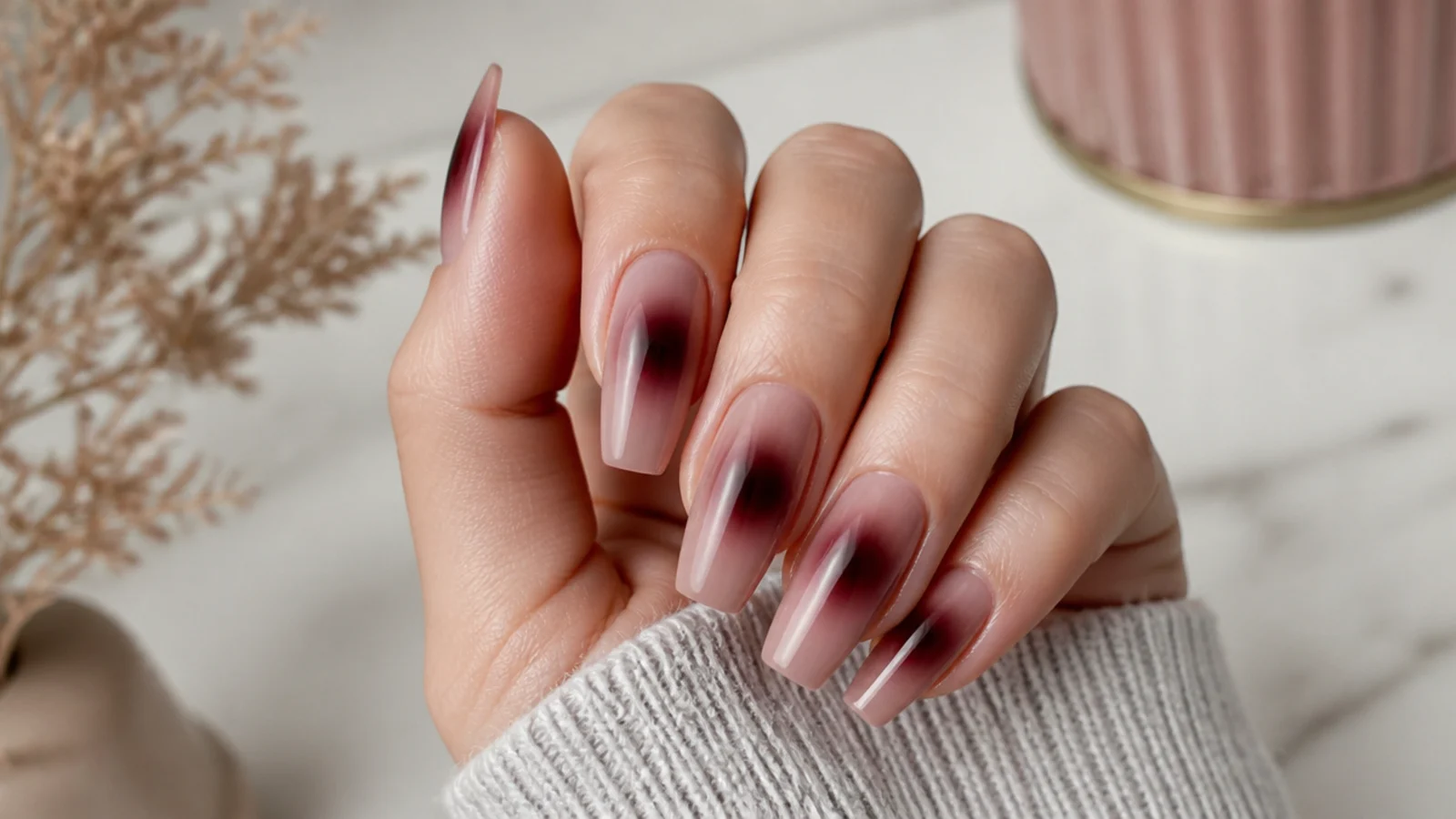 Coffin nails with a moody burgundy aura halo airbrushed on a smoky nude base