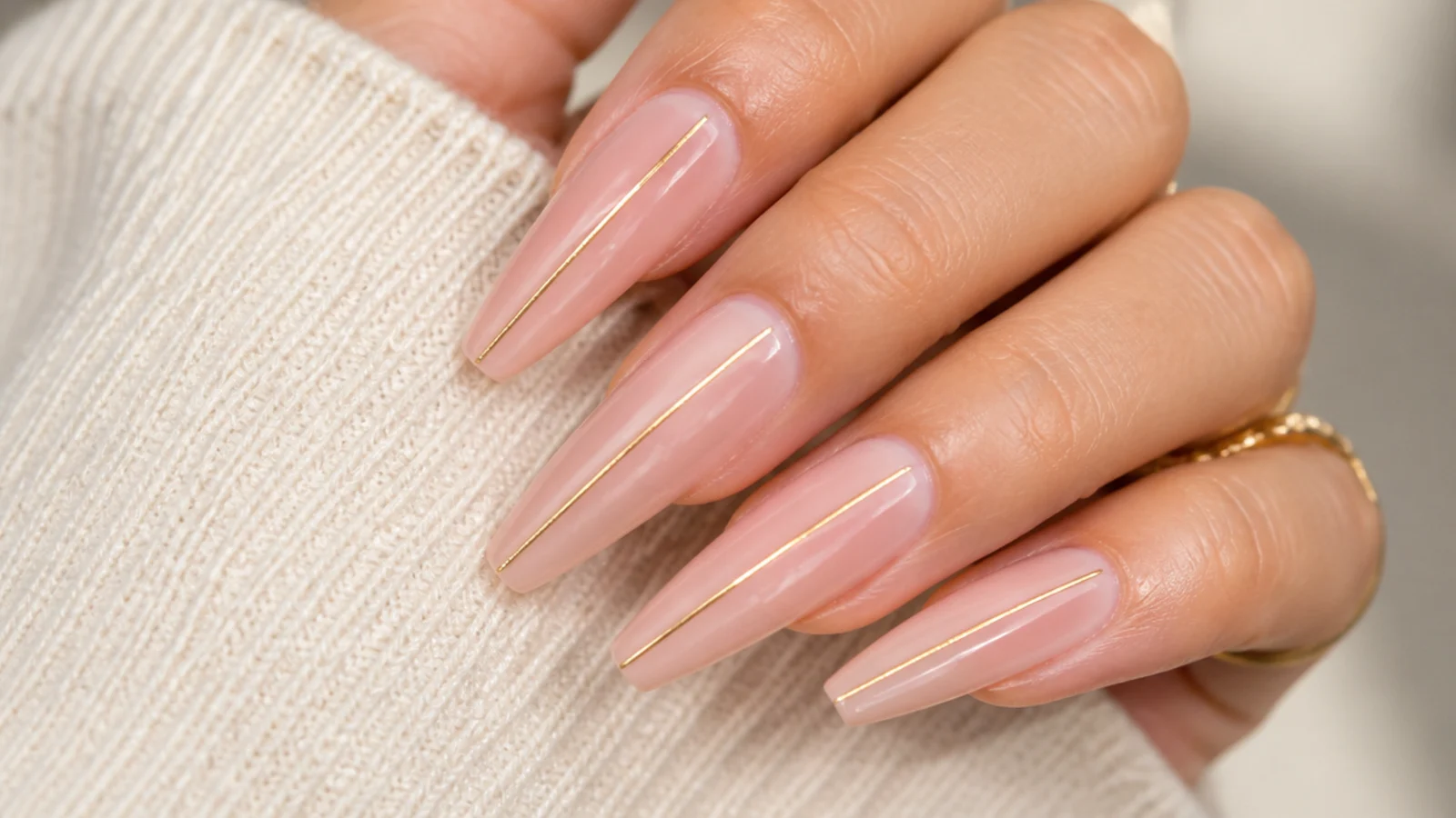 Long coffin nails with a single thin gold line running down the center of each nail