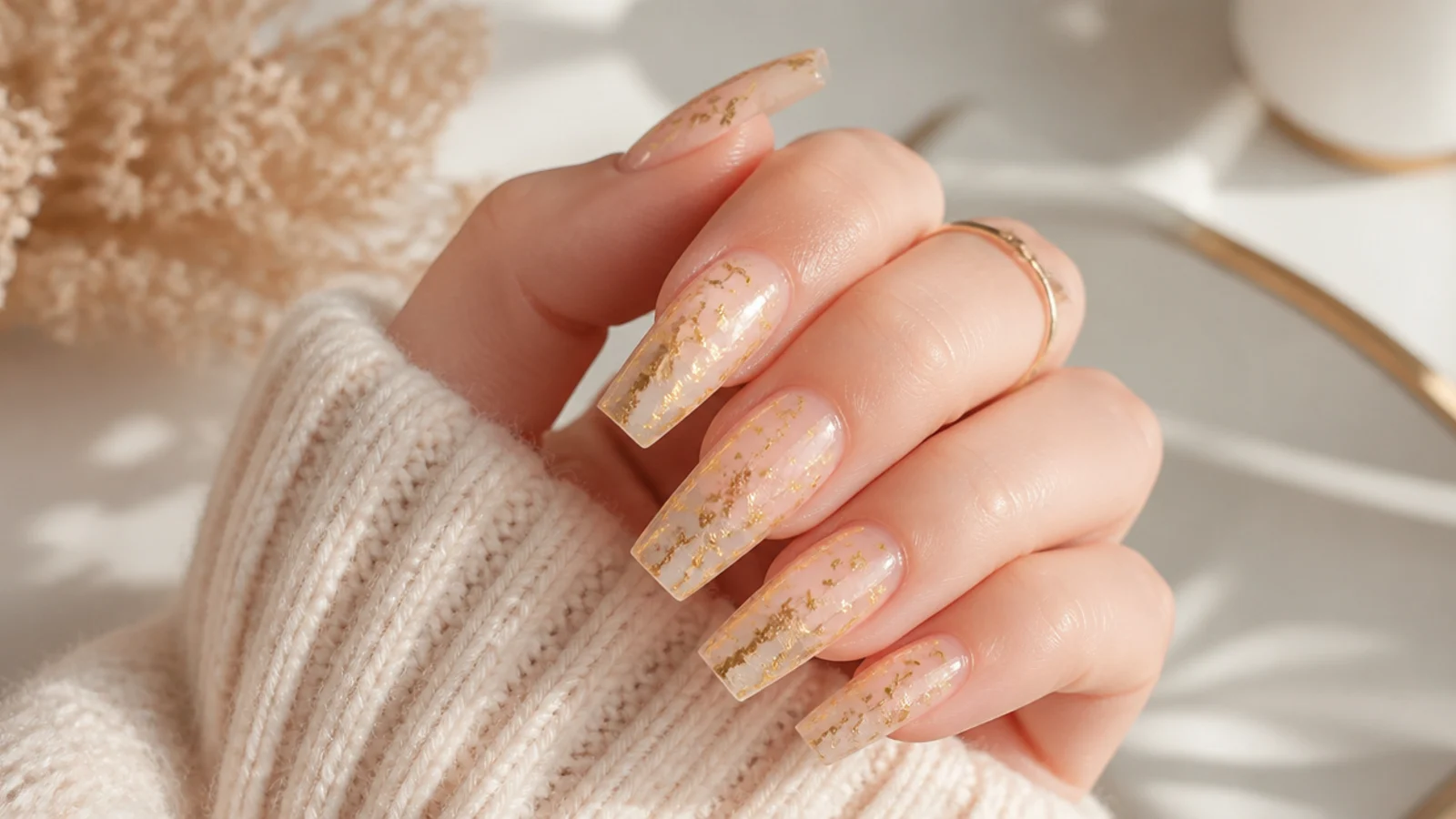 Long coffin nails with torn gold leaf flakes suspended over a nude base