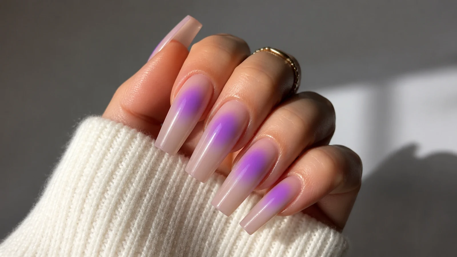 Long coffin nails with a glowing purple aura halo airbrushed at the center