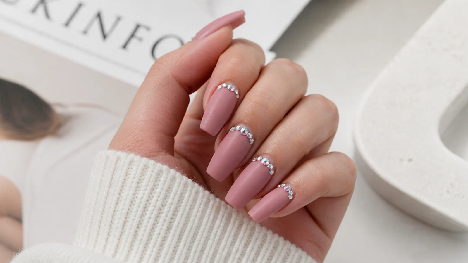 Matte pink velvet coffin nails with scattered rhinestones near the cuticle