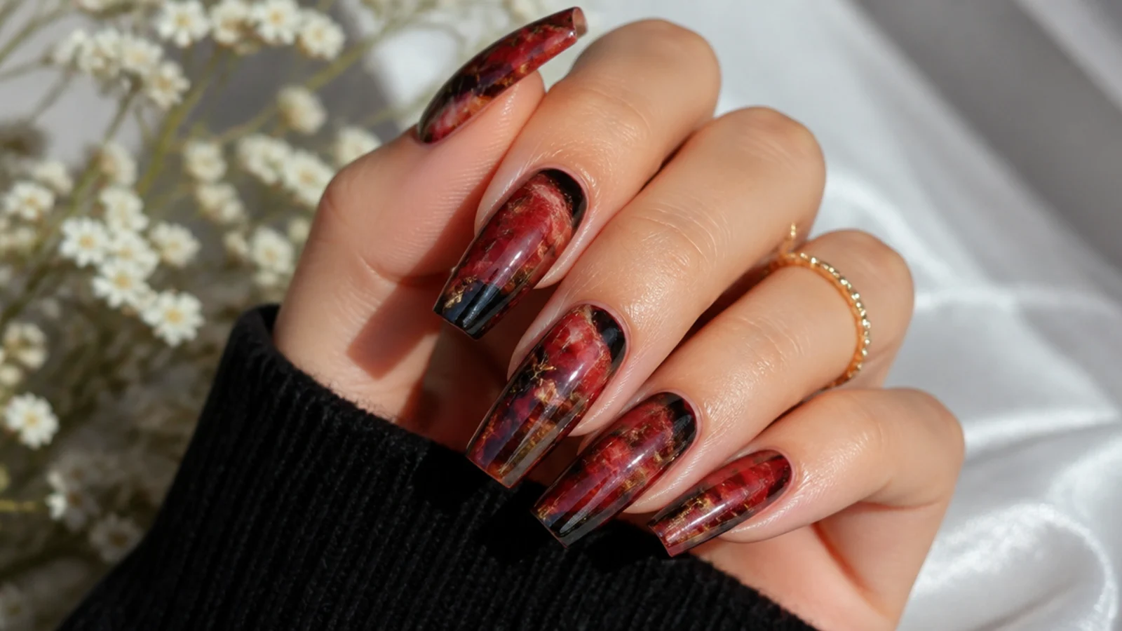 Red and black marbled coffin nails with fine veining across the flat tip