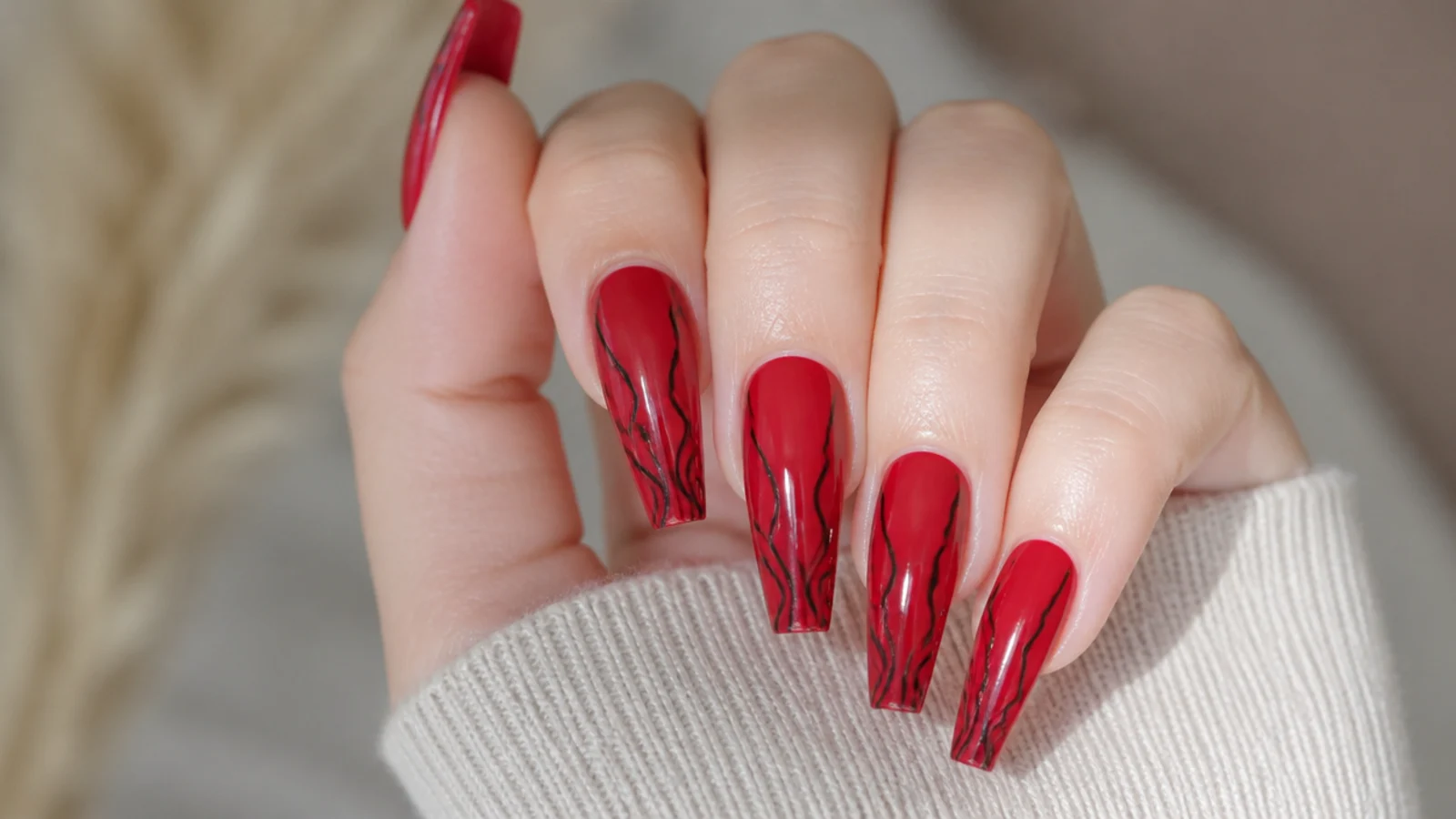 Red coffin nails with hand-painted black swirl lines running to the tip