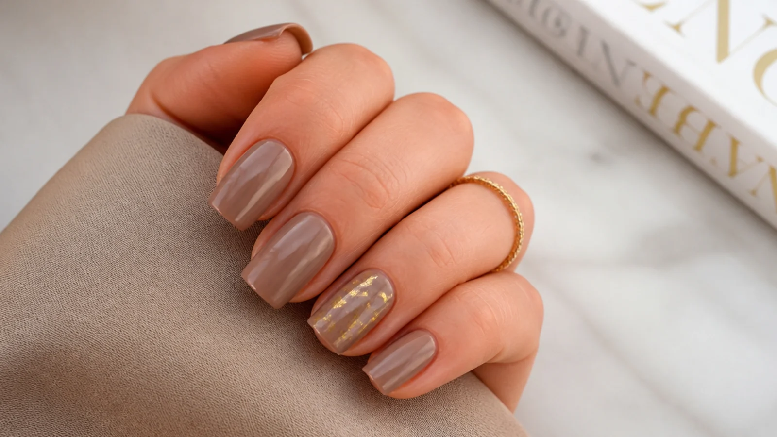 Short coffin nails in taupe with torn gold foil flakes on one accent nail