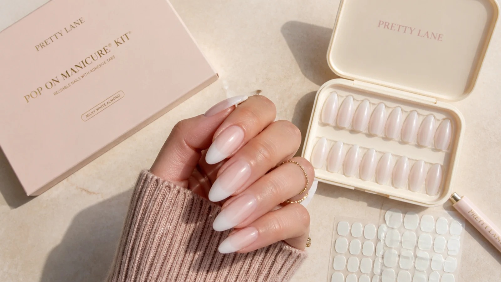 Reusable pop on manicure kit with milky white almond tips, adhesive tabs and a storage case