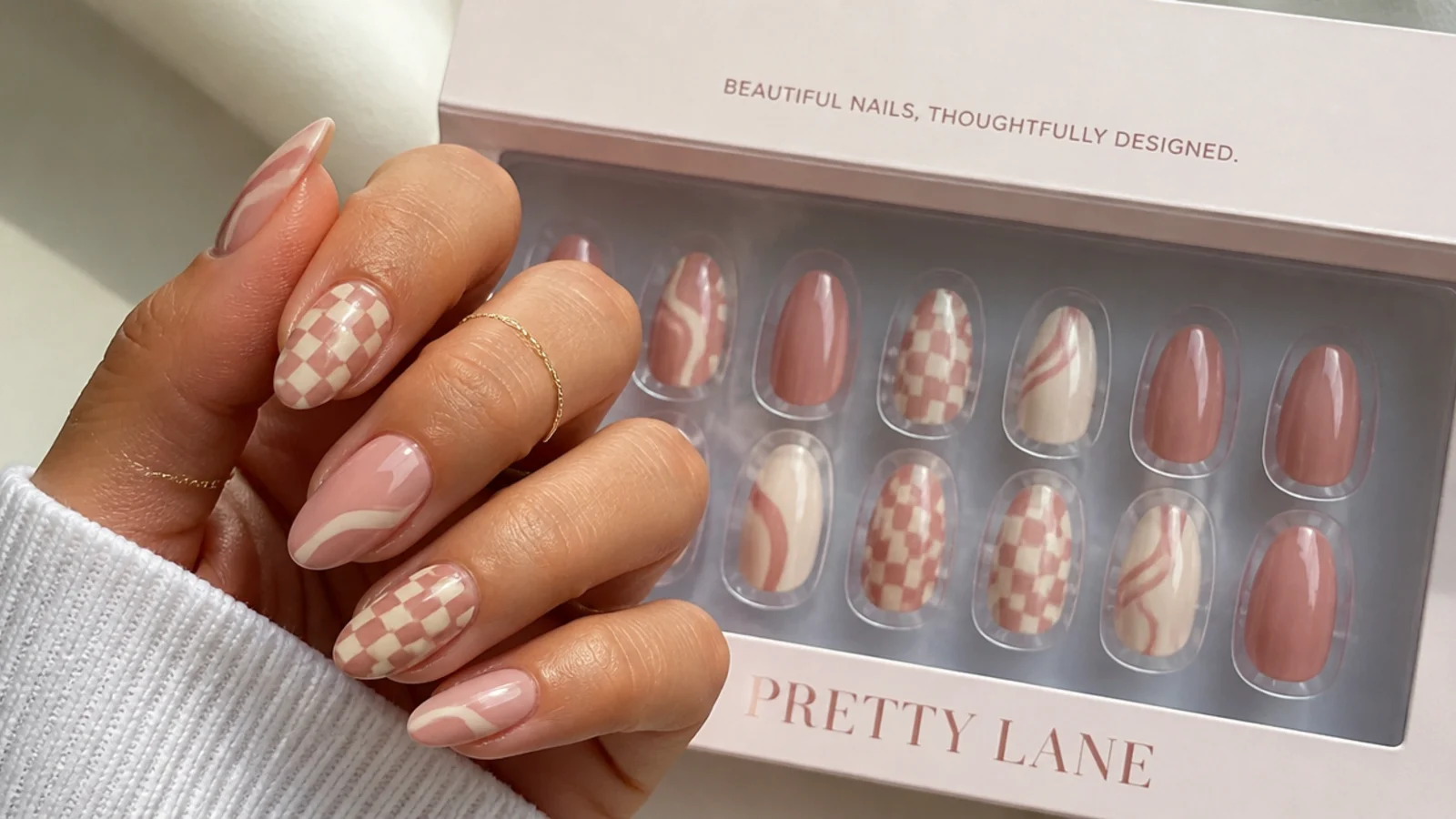Designed press on nail kit with hand painted style checkerboard and swirl tips in a flat tray