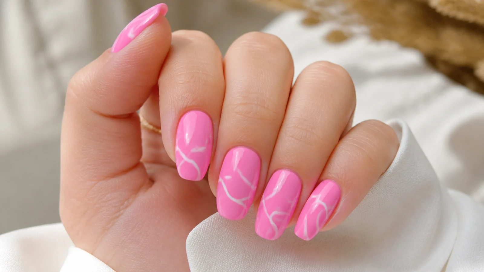 Bubblegum pink nails with looping white abstract swirl lines painted across each nail