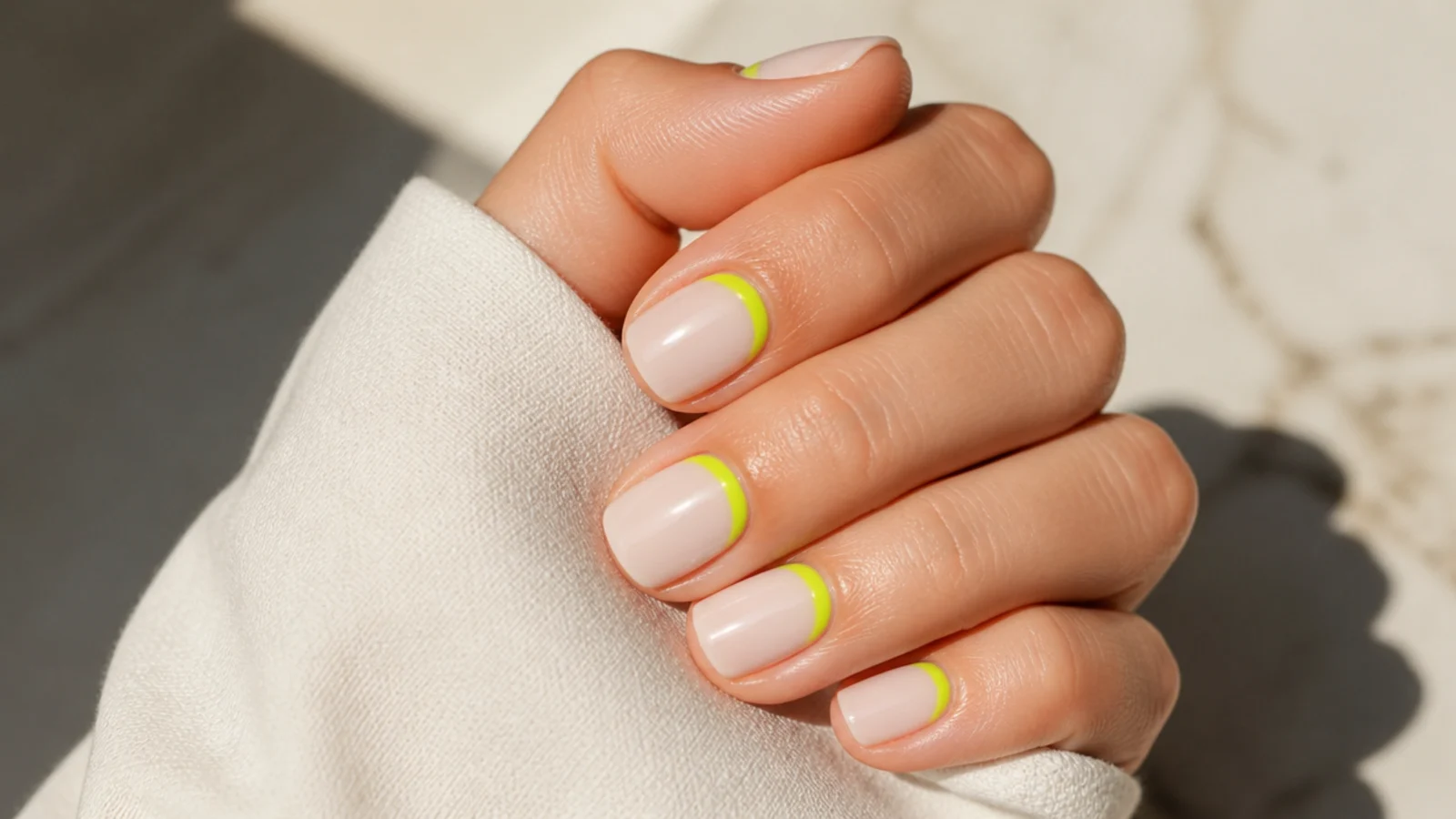 Short square nails with neon green flipped French color painted at the cuticle instead of the tip