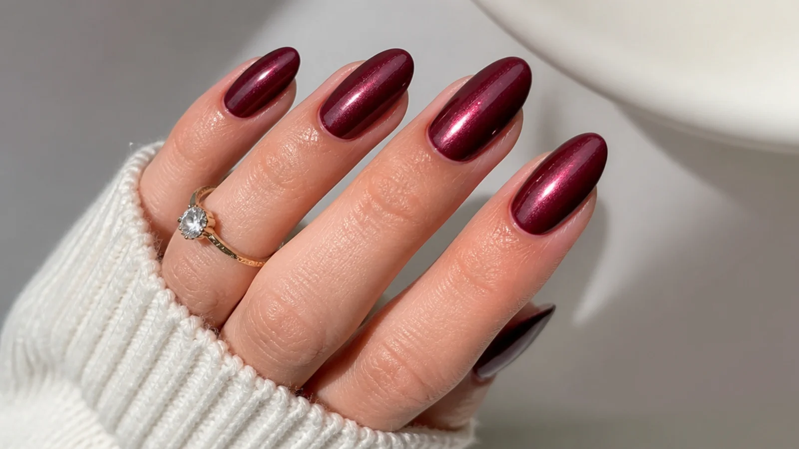 Burgundy almond acrylic nails with a pearl glazed shimmer