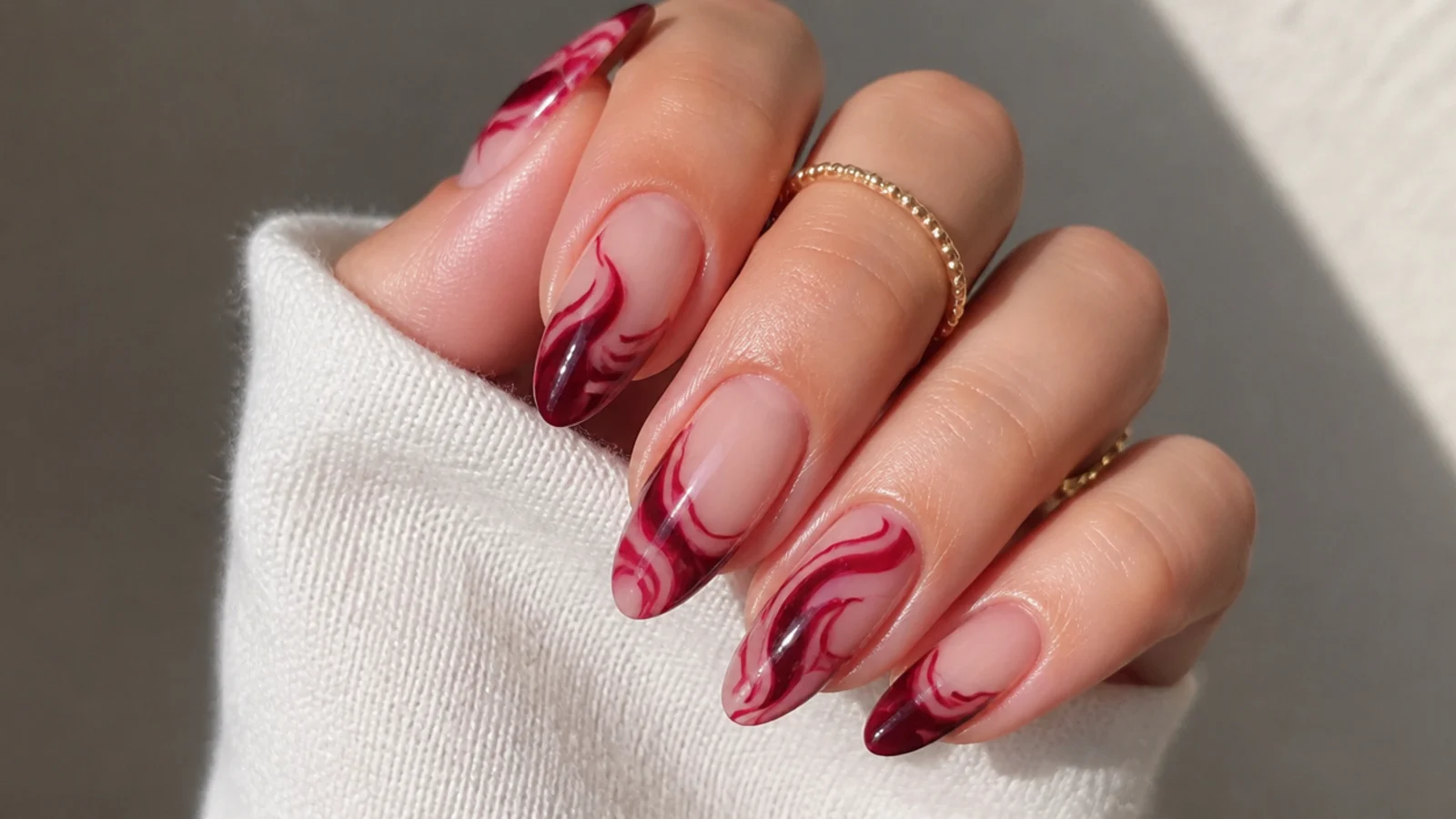 Almond acrylic nails with berry swirls over clear negative space