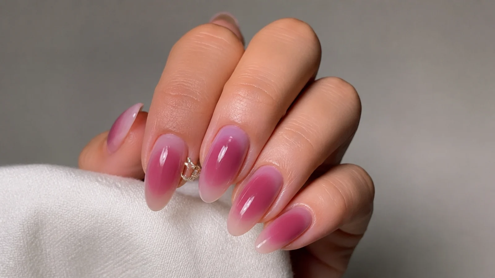 Almond acrylic nails with a soft sheer berry aura glow at the center