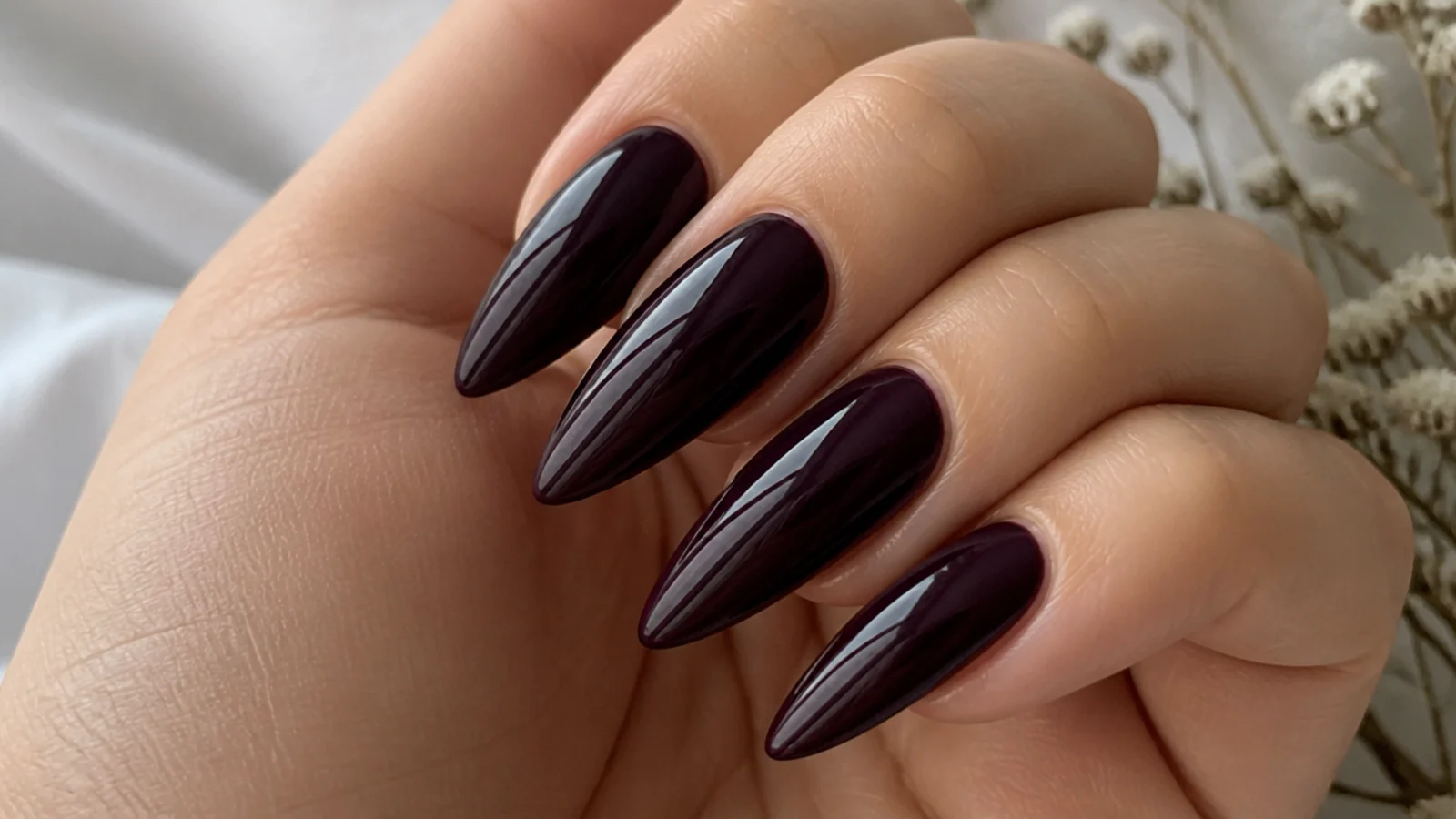 Blackened plum stiletto acrylic nails with a glossy finish