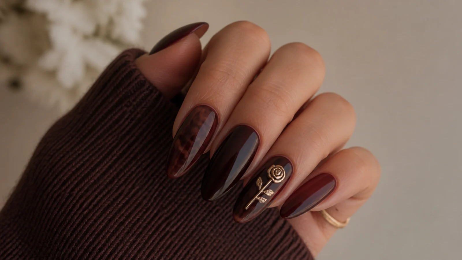 Deep warm-toned almond acrylic nails showing the dark feminine aesthetic
