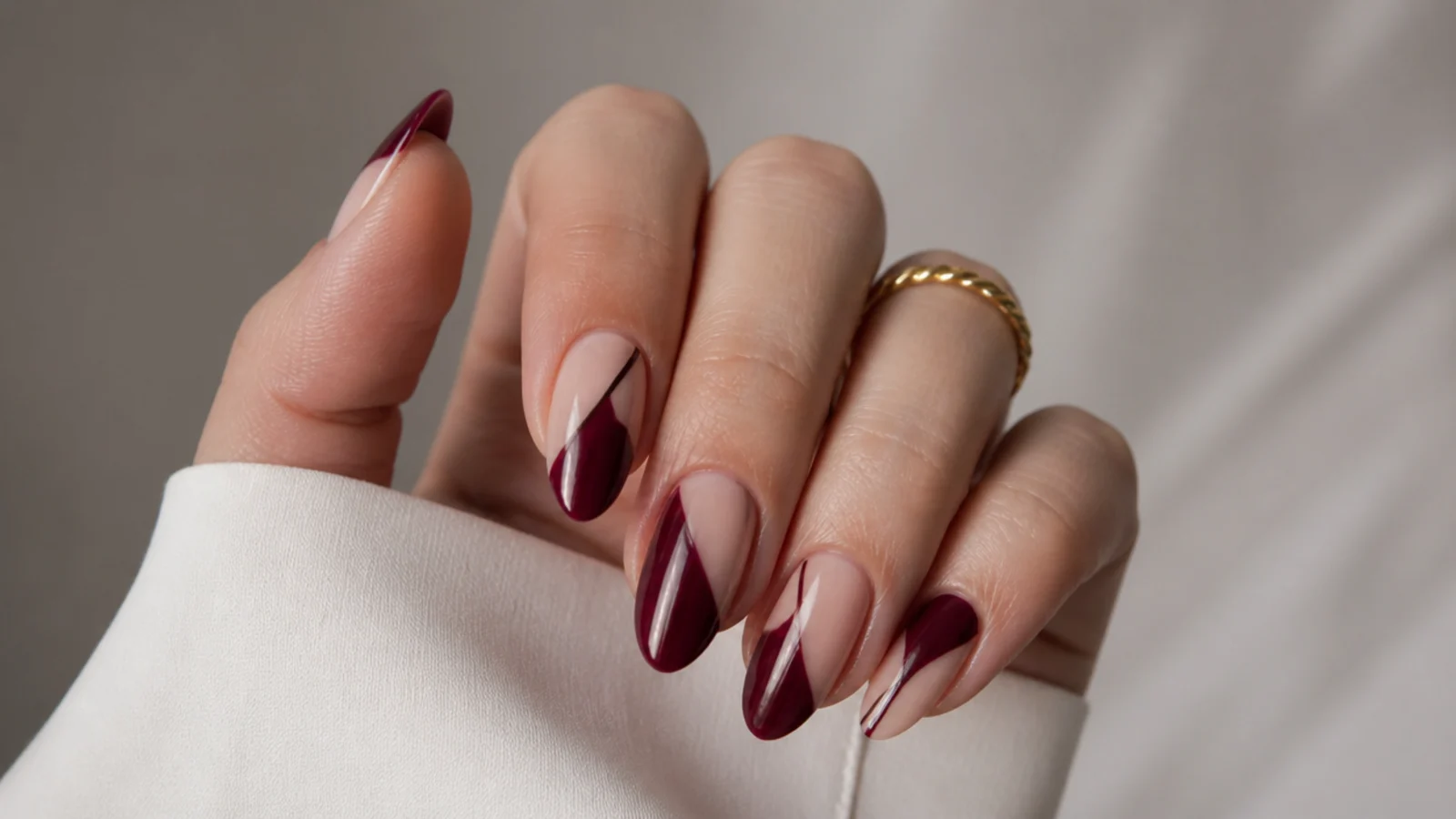 Deep berry negative-space dark feminine nails leaving bare nail exposed