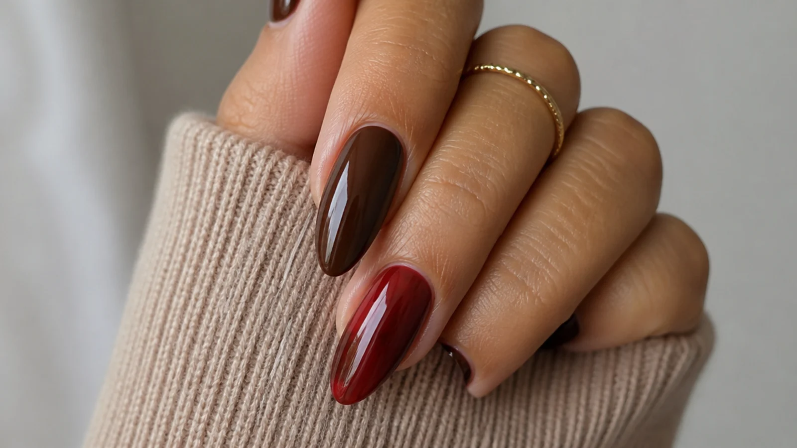 One office-appropriate chocolate nail beside a date-night sheer red nail