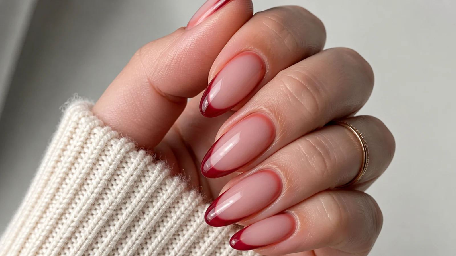 Sheer warm red almond nails with the natural nail showing through