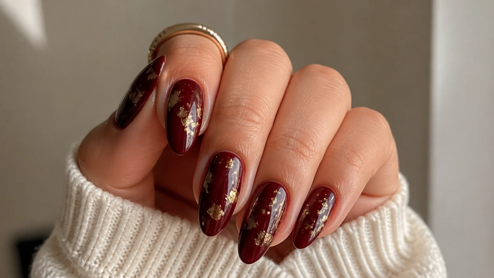 Deep wine almond nails with scattered gold foil flecks