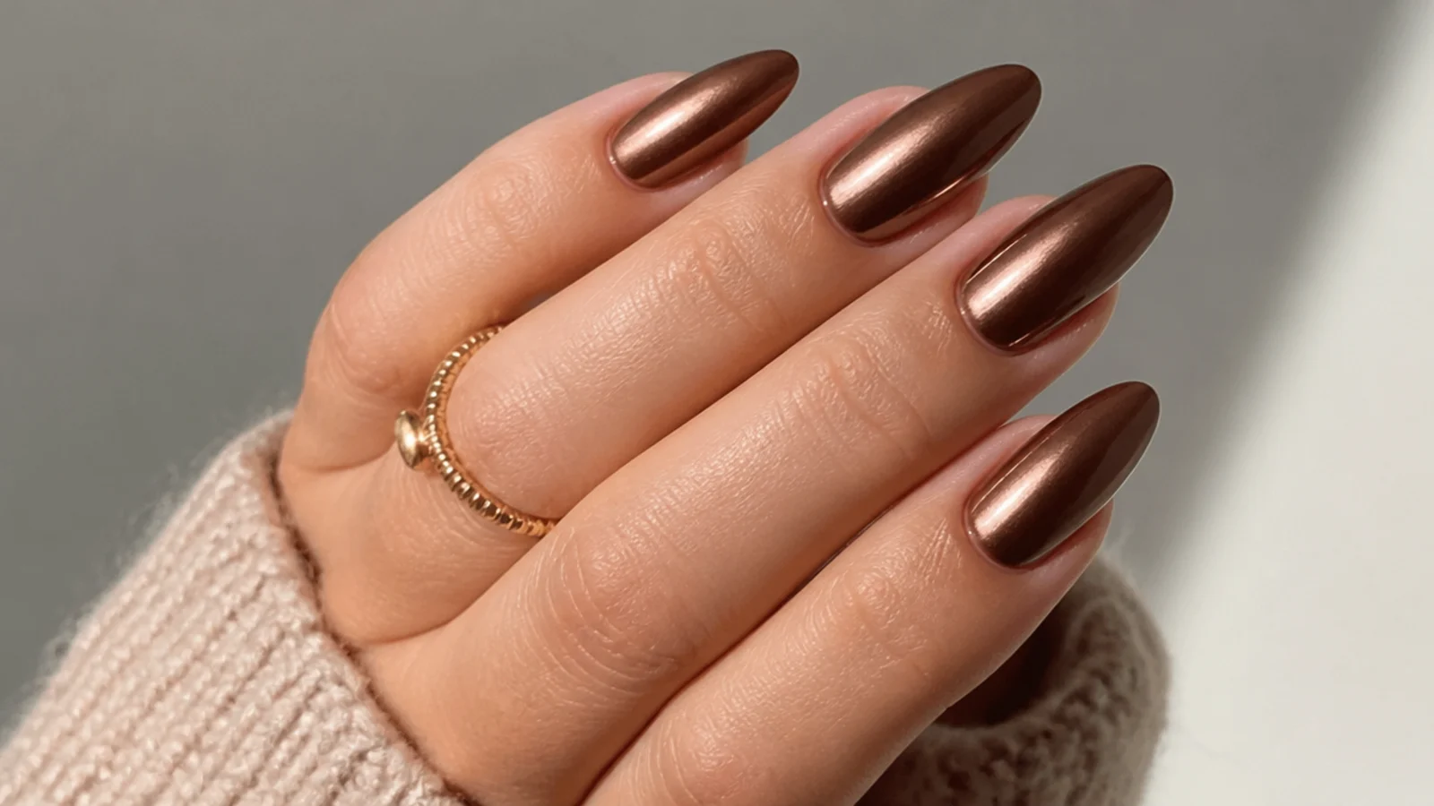 Chocolate brown almond nails with a metallic chrome sheen