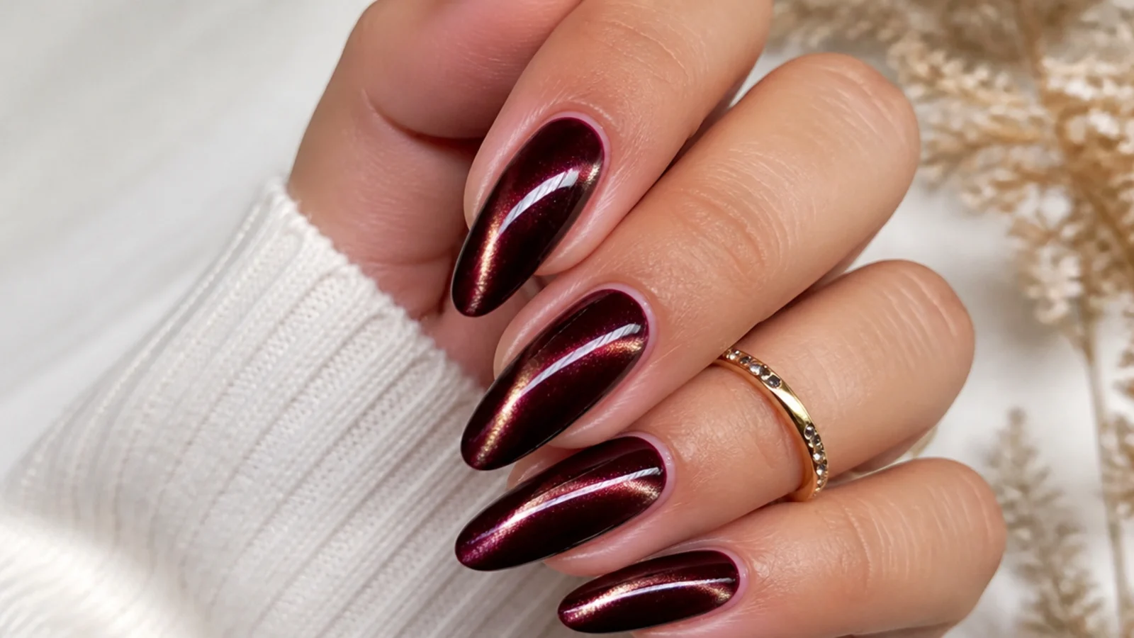 Deep merlot almond nails with a magnetic cat-eye shimmer stripe