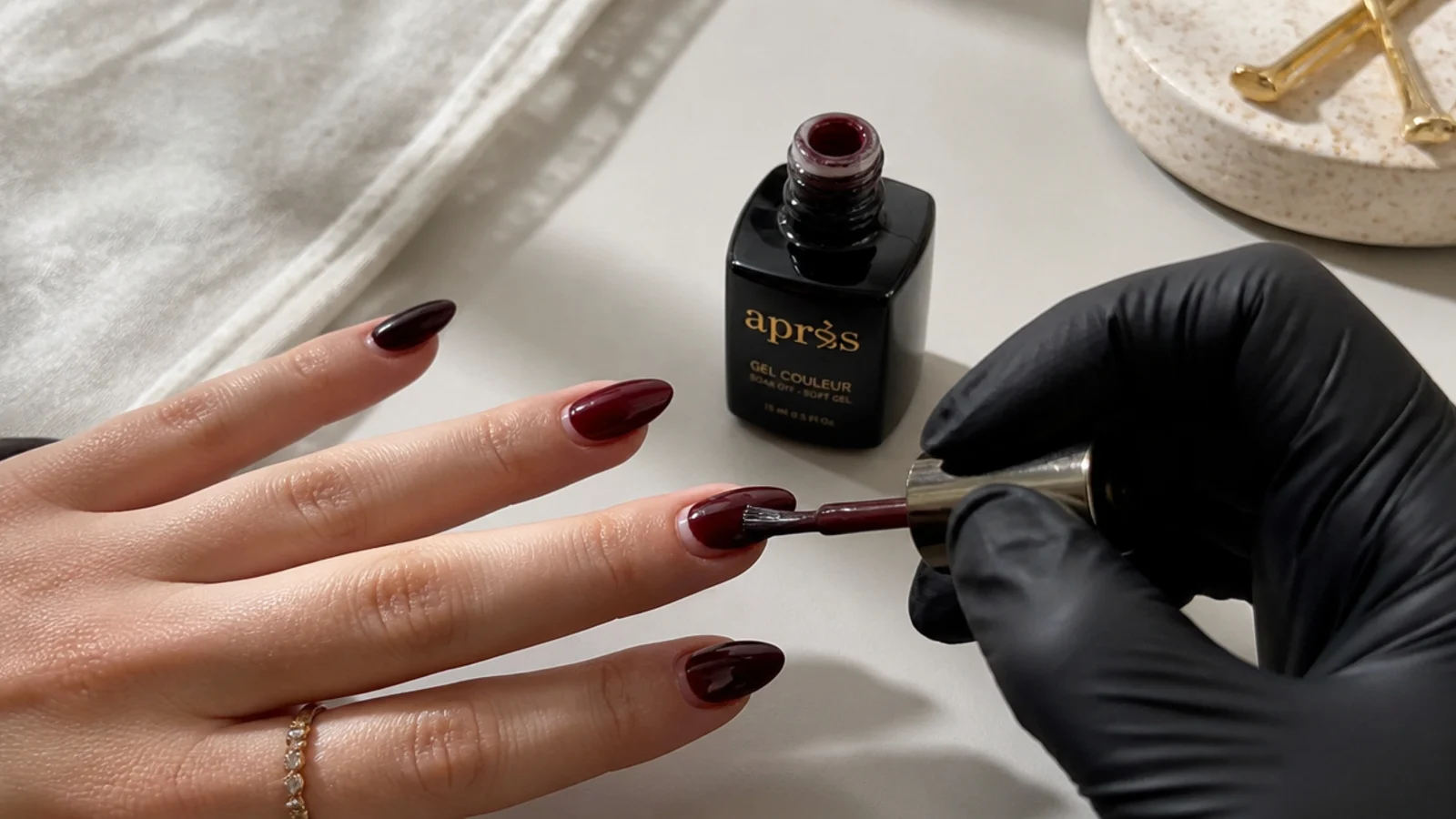 Dark feminine gel supplies and an almond nail mid-application at home