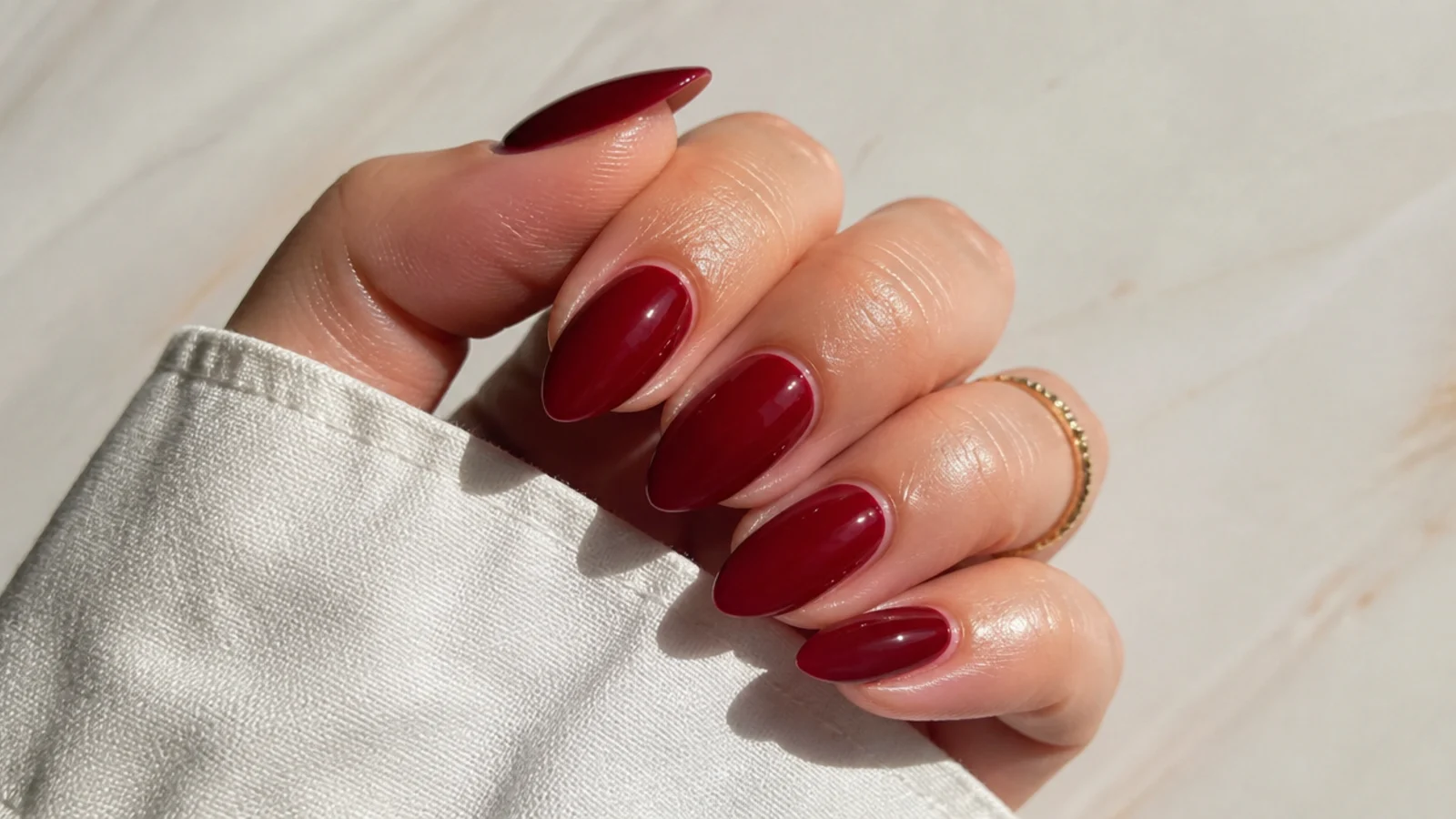 A well-sealed deep red almond manicure with cuticle oil for longevity