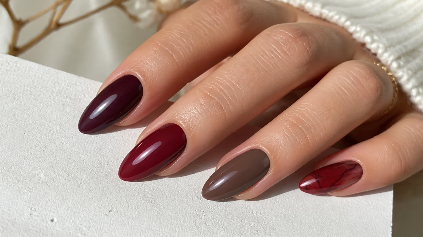 Swatches of berry, wine, oxblood, chocolate and sheer red almond nails