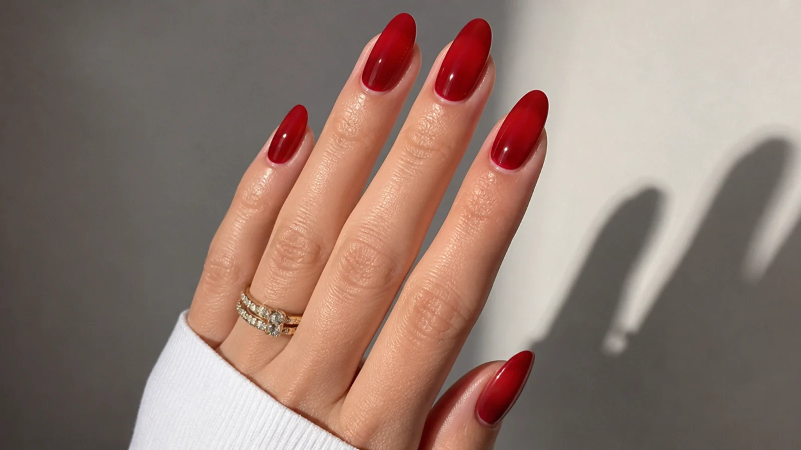 Sheer warm red jelly nails on almond shape, glossy and glassy