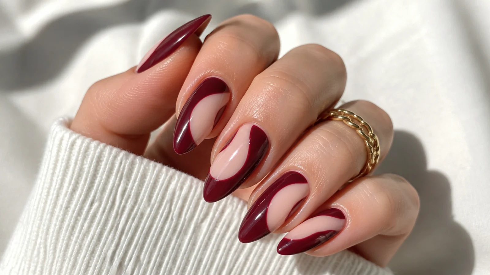Almond nails with oxblood painted around bare negative-space sections