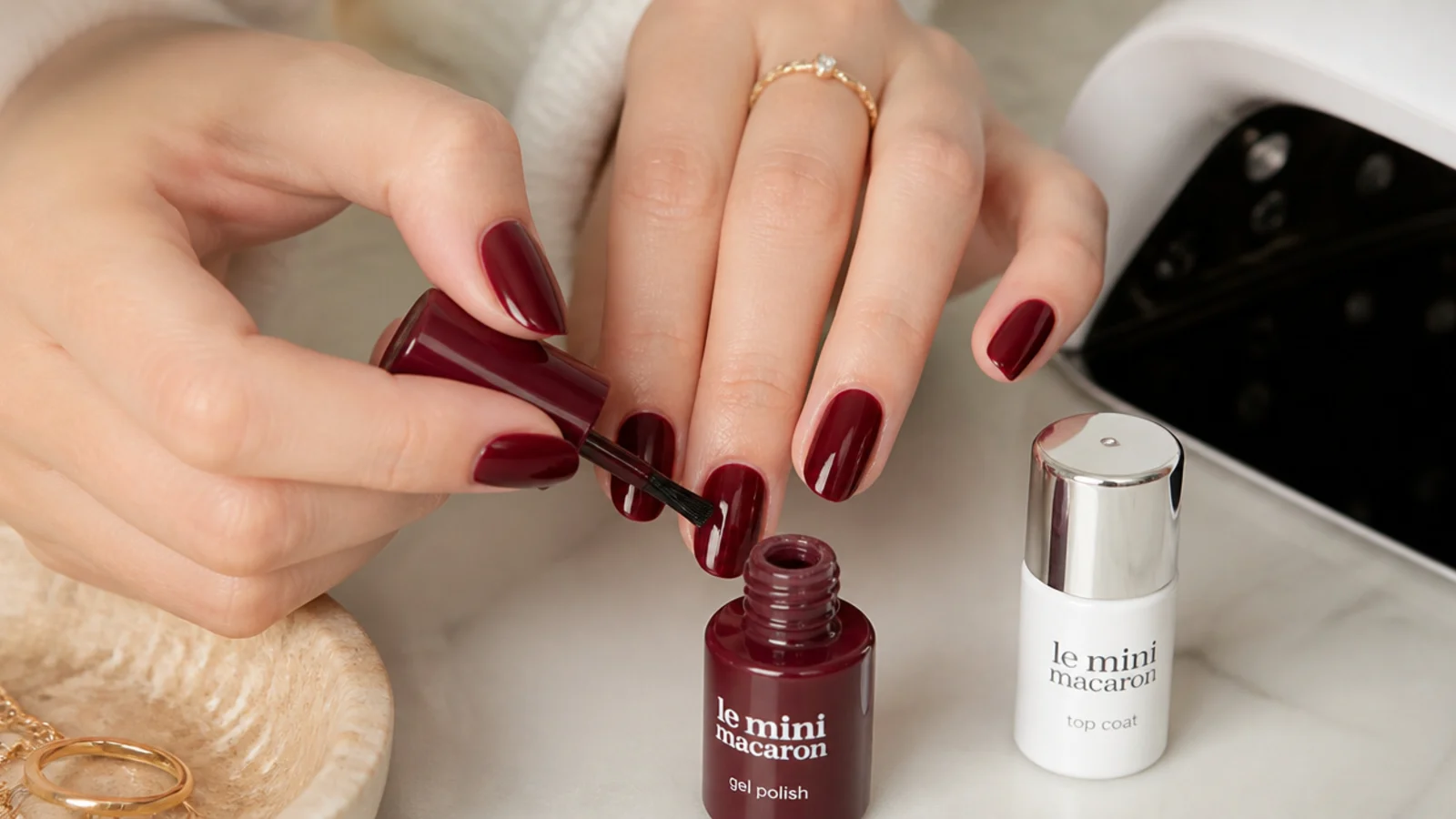 Deep oxblood gel being applied at home with a lamp and top coat