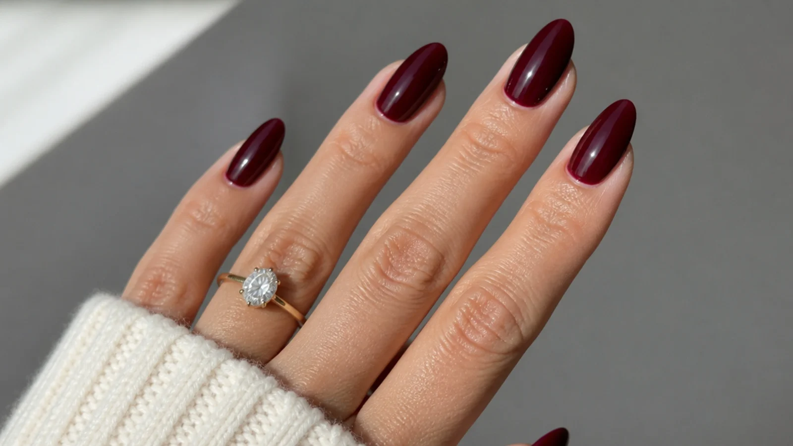 Glossy deep oxblood almond nails with a high-shine finish