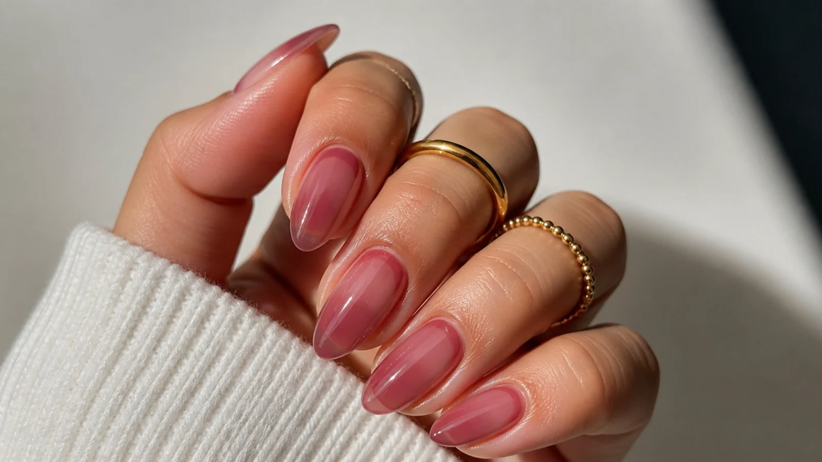 Sheer berry-tinted almond nails with the natural nail showing through