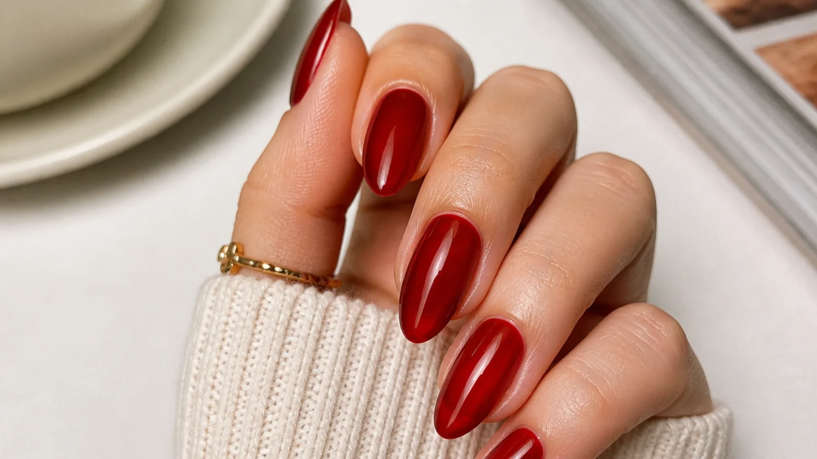 Sheer warm red almond nails with a glossy jelly finish for date night