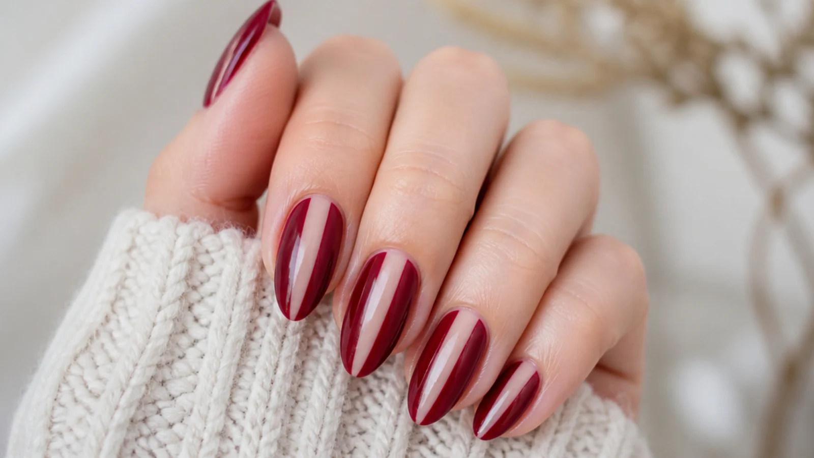 Deep berry almond nails with a bare negative-space stripe down the center