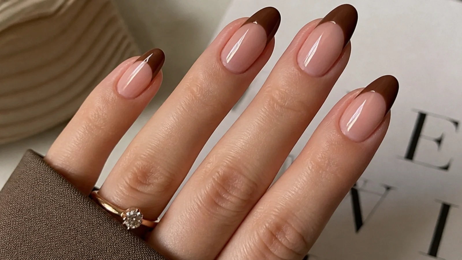 Nude almond nails with glossy chocolate brown French tips